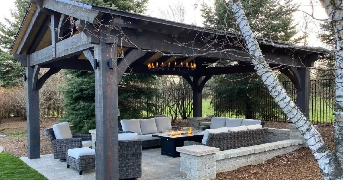 Timber-framed pavilion with outdoor seating and fire table.